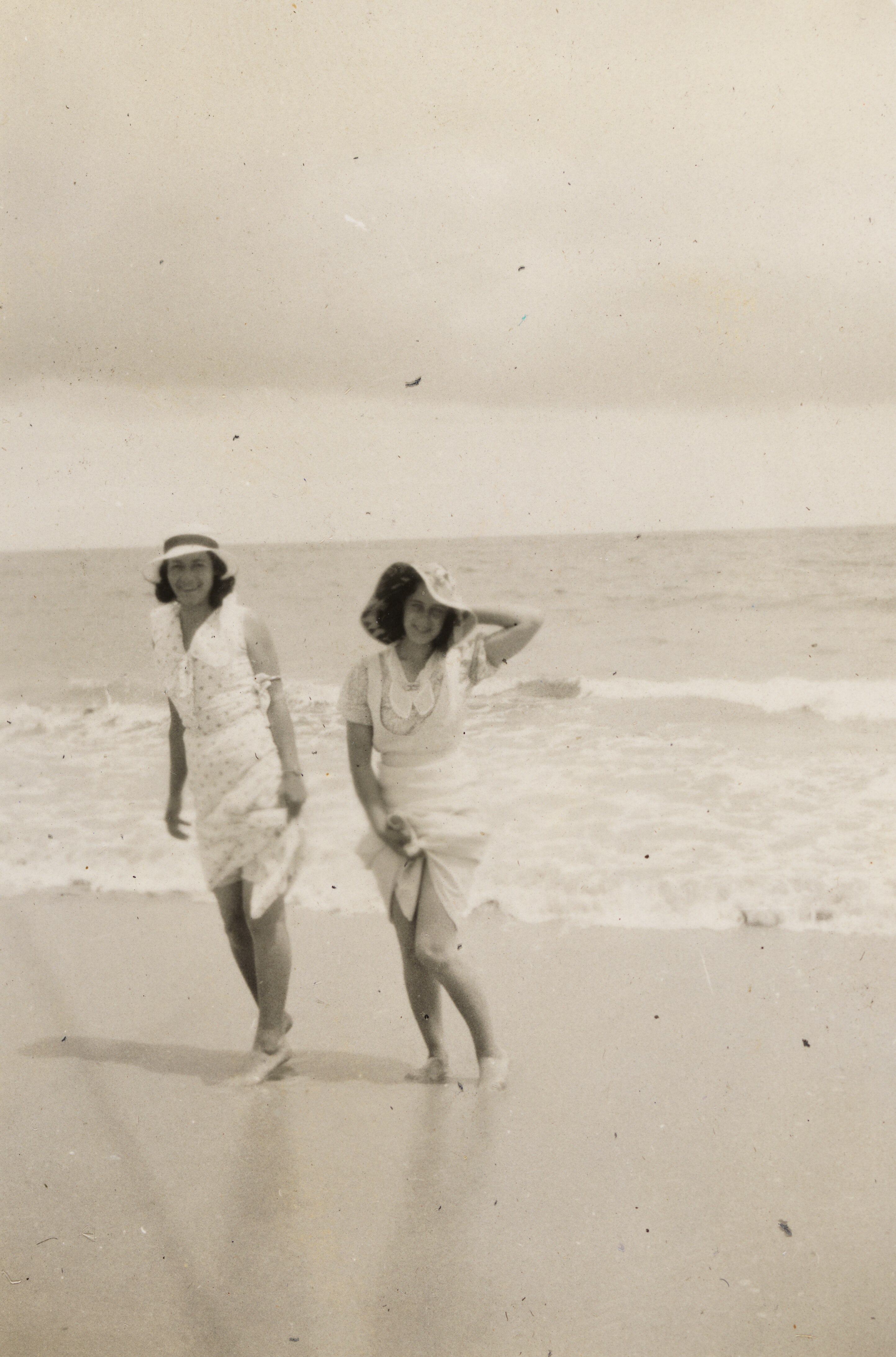 Dos mujeres en una fotografía en blanco y negro se encuentran en el agua de la playa. 