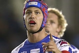 Newcastle Knights player Kalyn Ponga points while standing still during an NRL game.