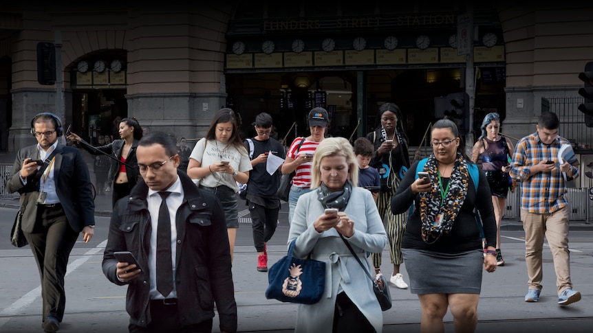 A photo illustration shows 11 people looking at their phones as they cross the road.