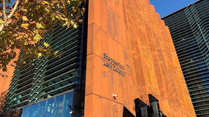 A photo of the outside of the Shepparton courthouse which has a orange, rustic exterior and modern, wavy, glass windows.