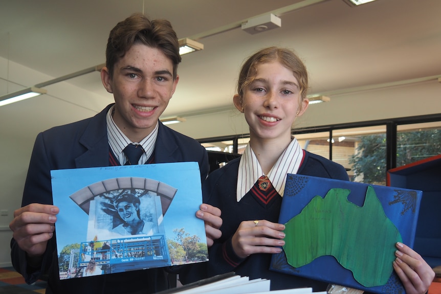 An image of Abbey and Hudson holding up artwork in their school