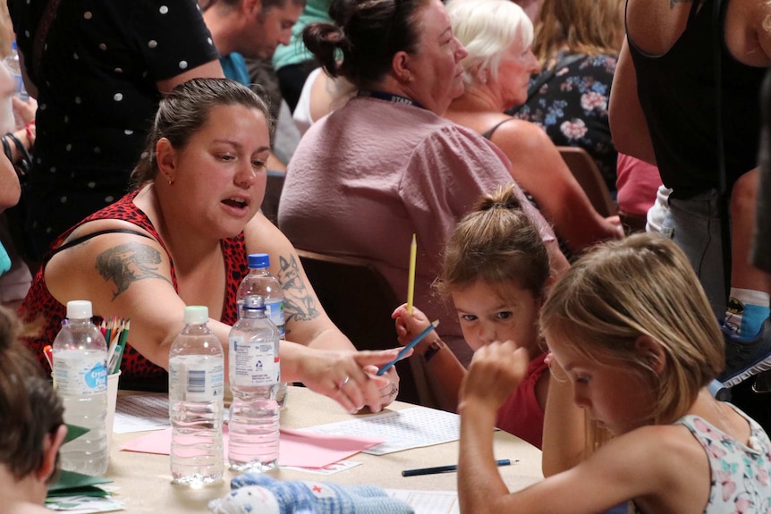 Children at a table drawing during the community fire meeting.