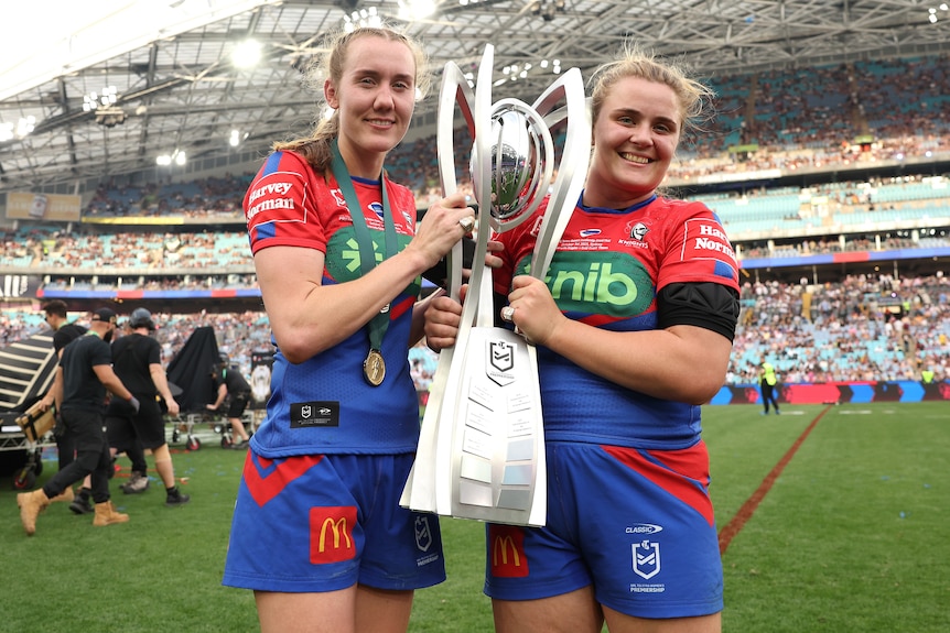 Tamika Upton and Hannah Southwell with the NRLW premiership trophy.