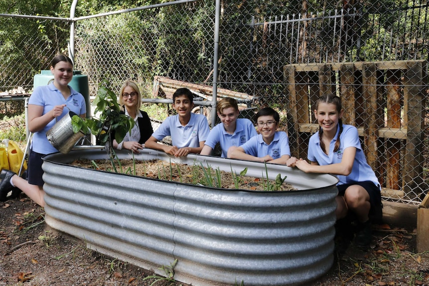 Teacher and students at Hunters Hill High sitting around their vegetable patch