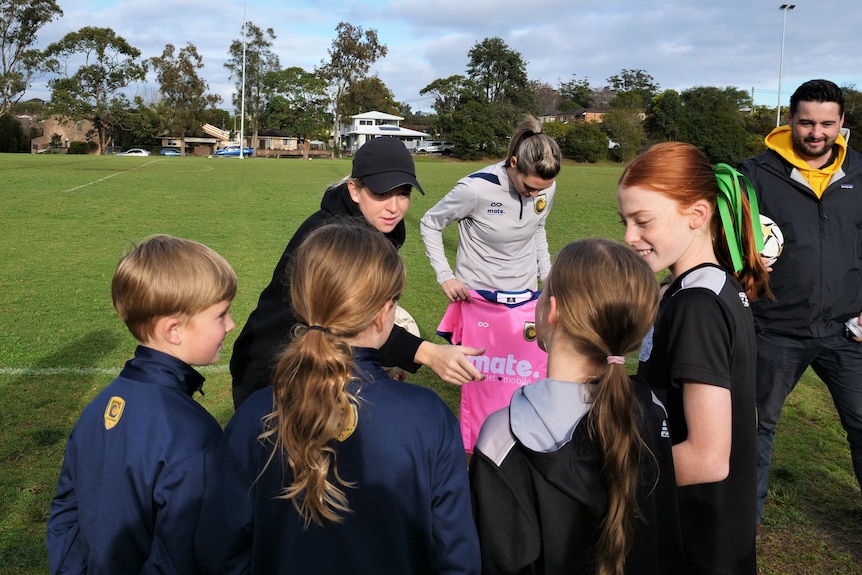 Fran Hurndall speaking with young female soccer players