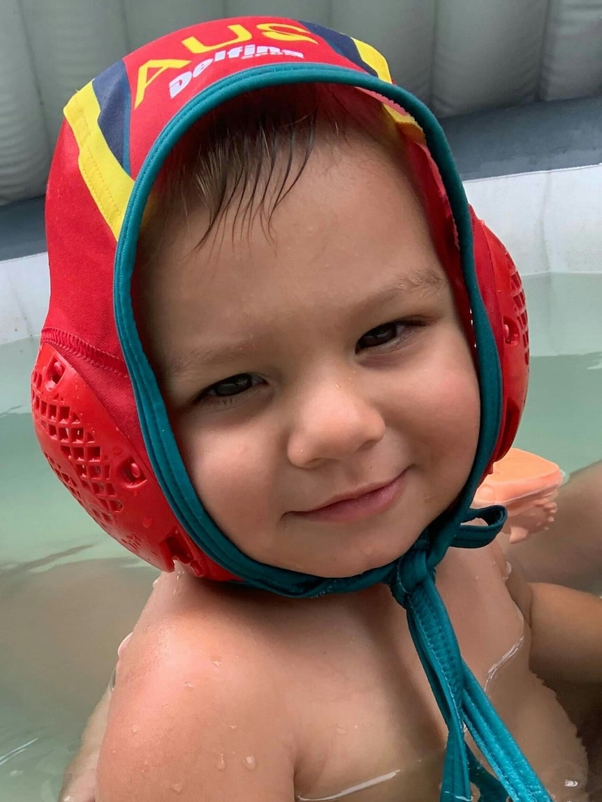 Photo of a baby wearing a water polo cap