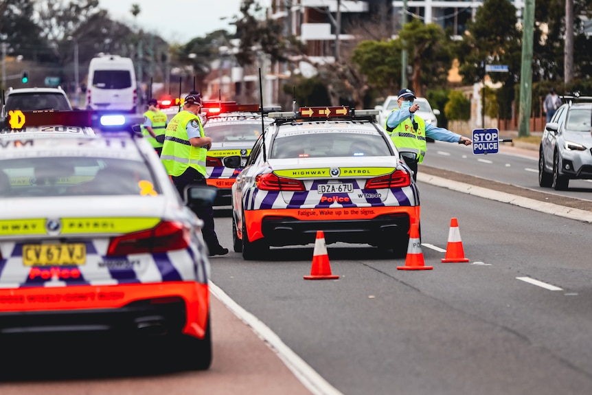 Police stopping people in cars at a roadblock