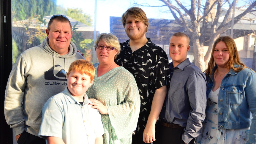 A portrait of a family of six people smiling at the camera.