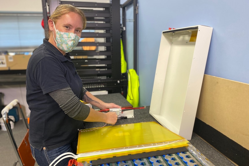 a woman with electrical tools in a factory