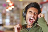 A man is singing his heart out with headphones on.