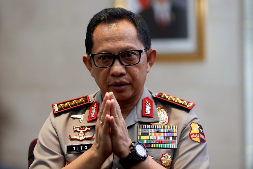 Indonesian police chief Tito Karnavian clasps his hands together