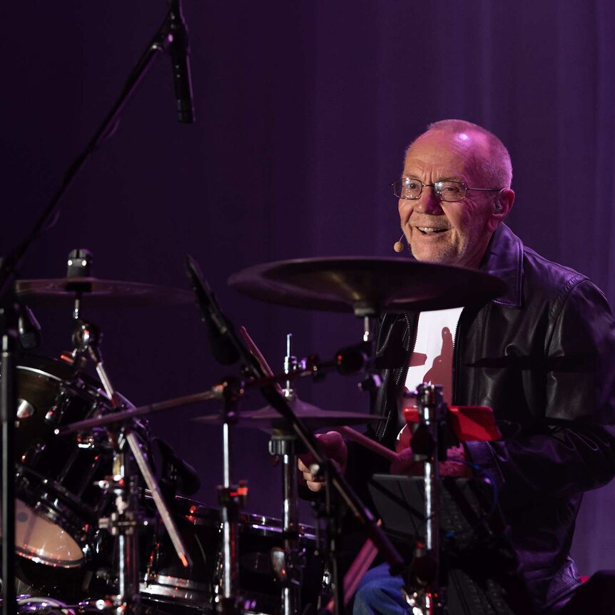 Colin Petersen sitting behind his drums onstage with the best of the Bee Gees show