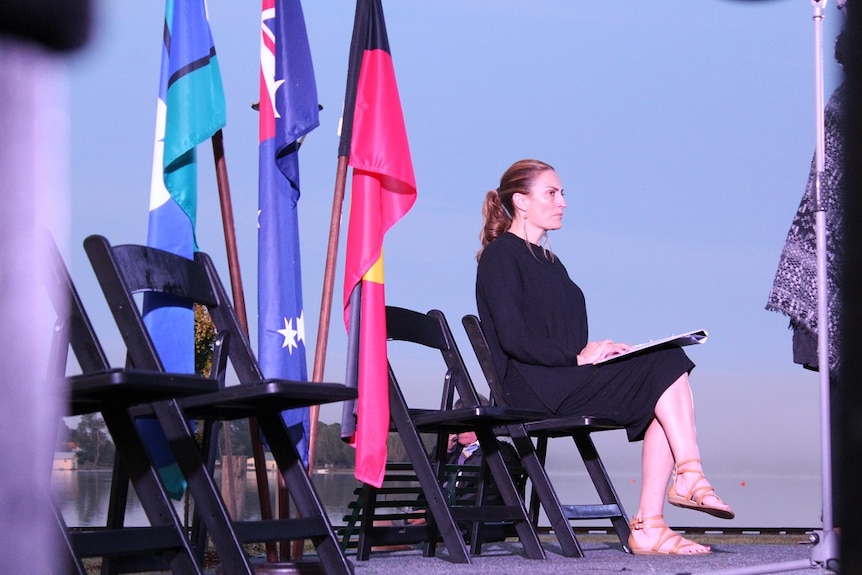 Co-chair of Reconciliation Victoria, Belinda Duarte, next to various flags.