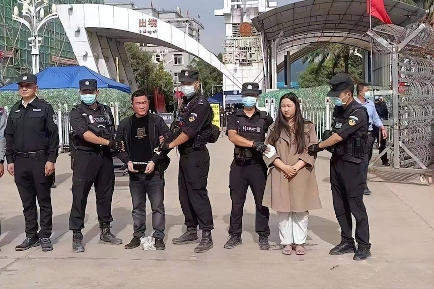 Ming Guoping and Ming Julan in handcuffs with Chinese police. 