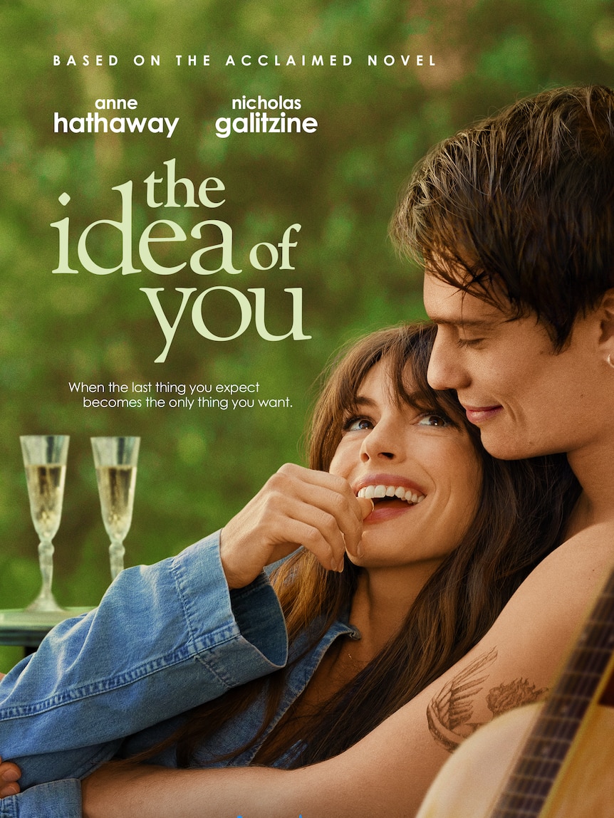 A poster featuring Anne Hathaway in an embrace and in character with Nicholas Galitzine, wine glasses behind them