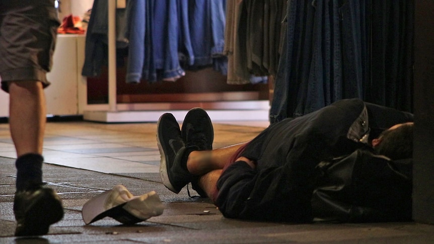 A homeless man sleeps on a Surfers Paradise street