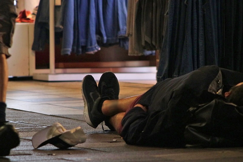 A homeless man sleeps on a Surfers Paradise street