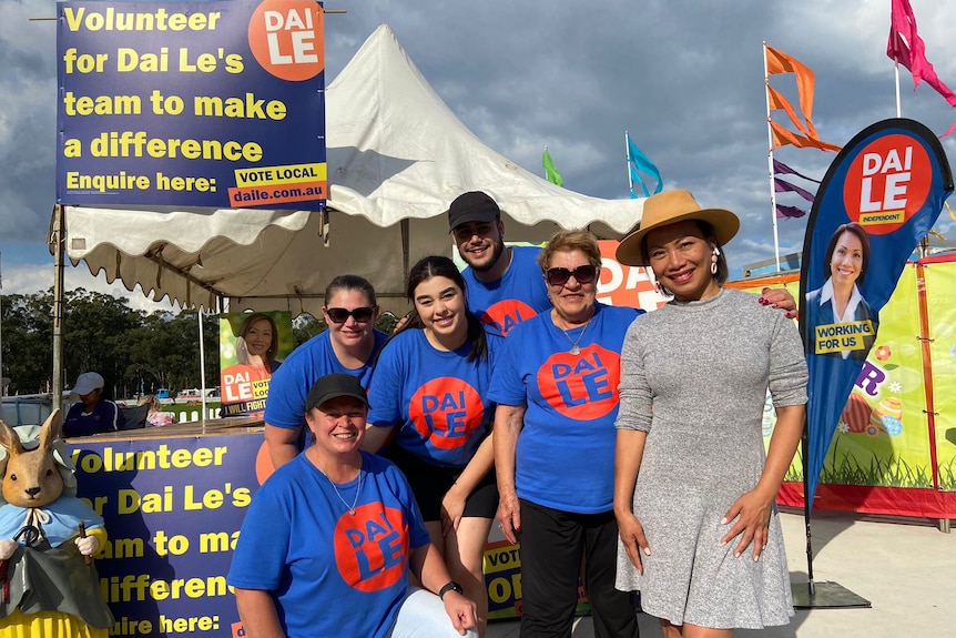 Dai Le and a small group of her campaign team pose for a photo in blue 'Dai Le' t-shirts and posters