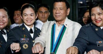 Duterte fist bumps with female military officers in the Philippines