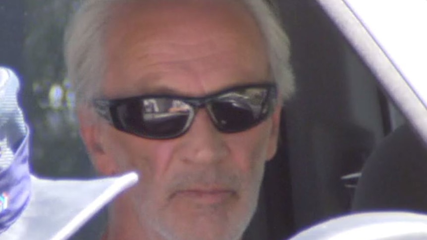 A close-up shot of a man in his vehicle wearing shades.