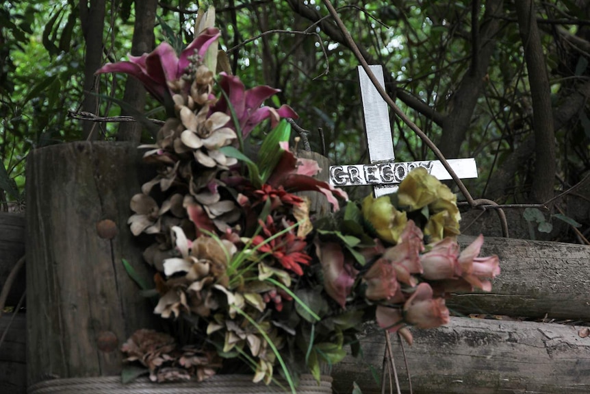 A photo of a floral memorial at Cahill's Crossing.