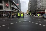 Police stand in the middle of an intersection.