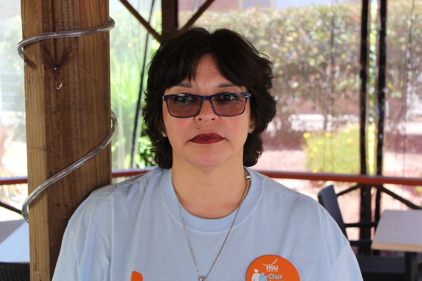 Headshot of a woman with short brown hair, wearing tinted glasses.