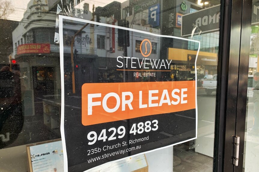 A Steveway Real Estate "For Lease" sign in a shop window.