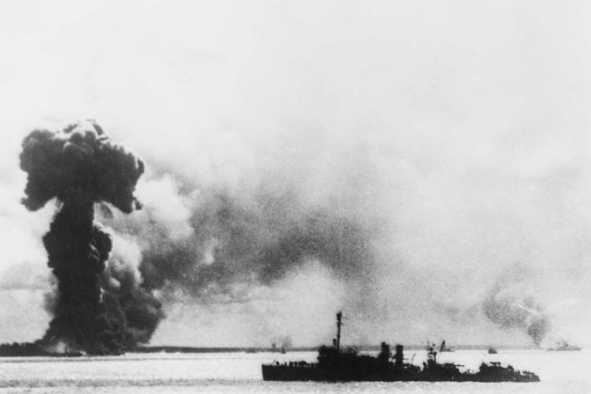 An explosion of the water, a ship floats in the foreground