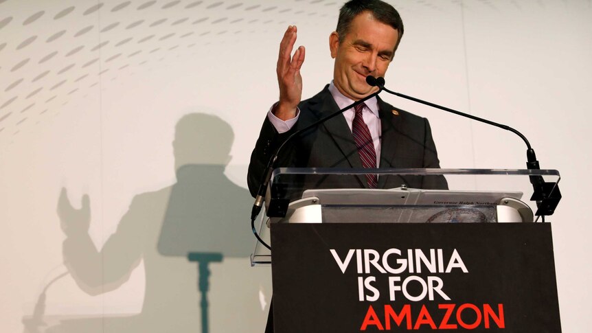 Virginia Governor Ralph Northam speaks in front of a "Virginia is for Amazon lovers" sign