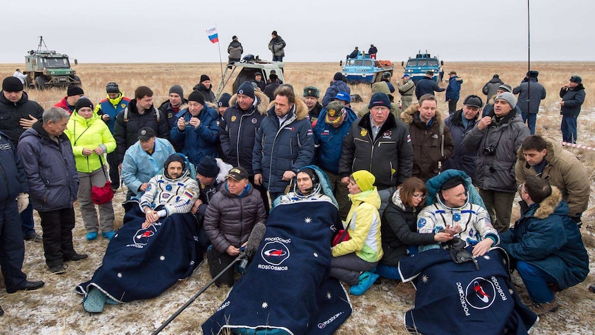 Space crew back on land surrounded by supporters