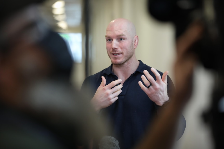 A close up shot of David Pocock speaking with the blurred media members in the foreground