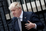Boris is seen holding a folder
