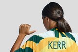 Sam Kerr points her thumbs at her back, which has her name and number, 20, displayed