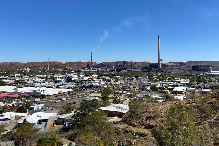 Town in the desert with three large smoke stacks