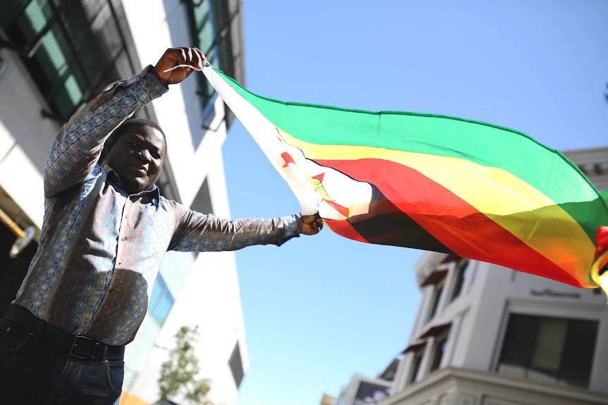 Vusumuzi 'BB' Gumbo lifts the Zimbabwean flag.