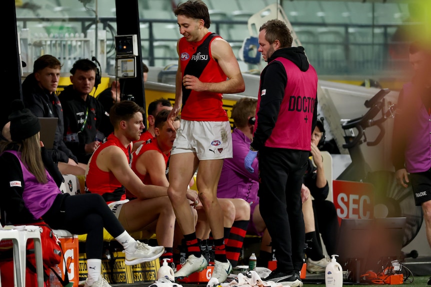 Nic Martin looks sore on the Essendon bench