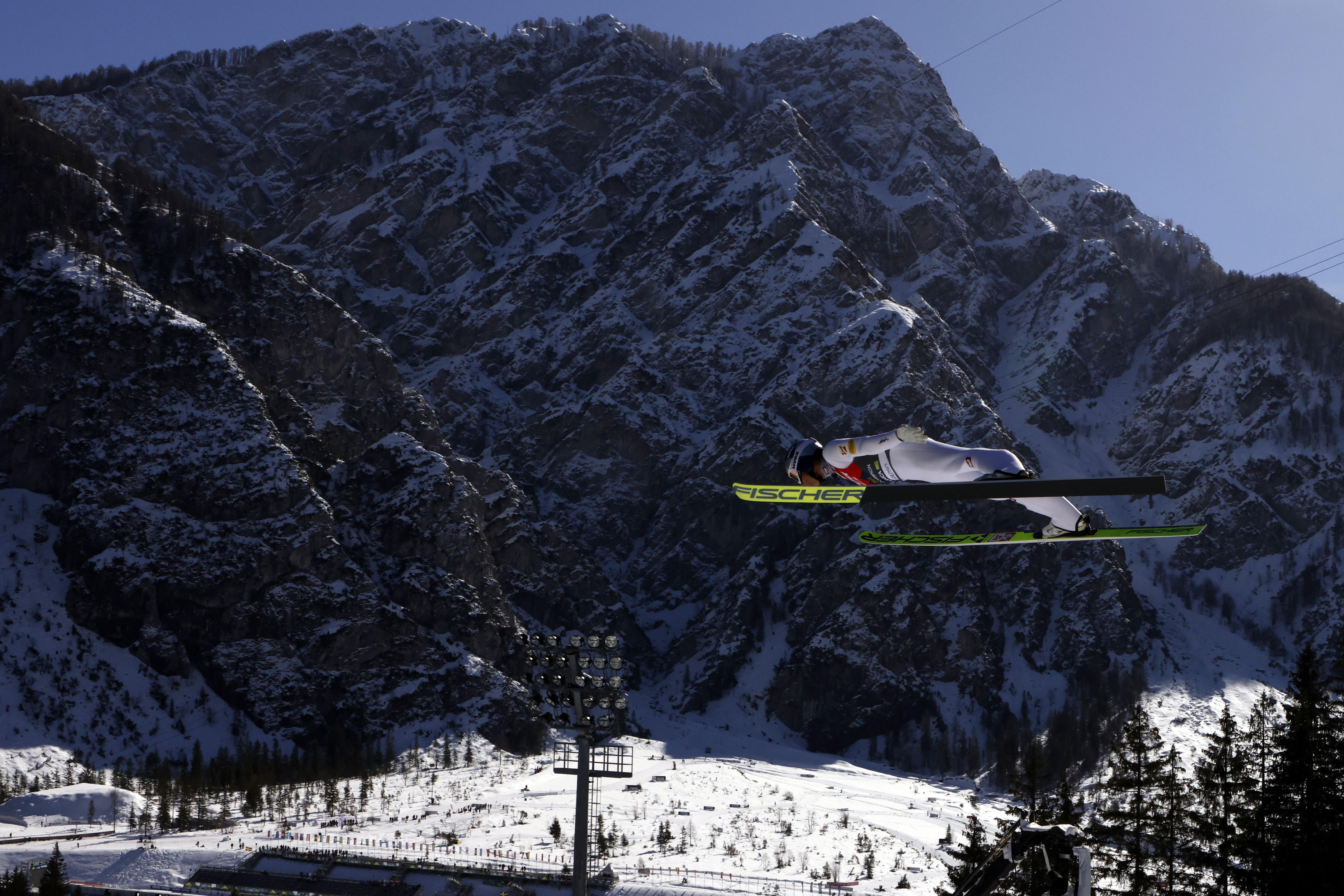 Johannes Lamparter leaps in front of a mountain