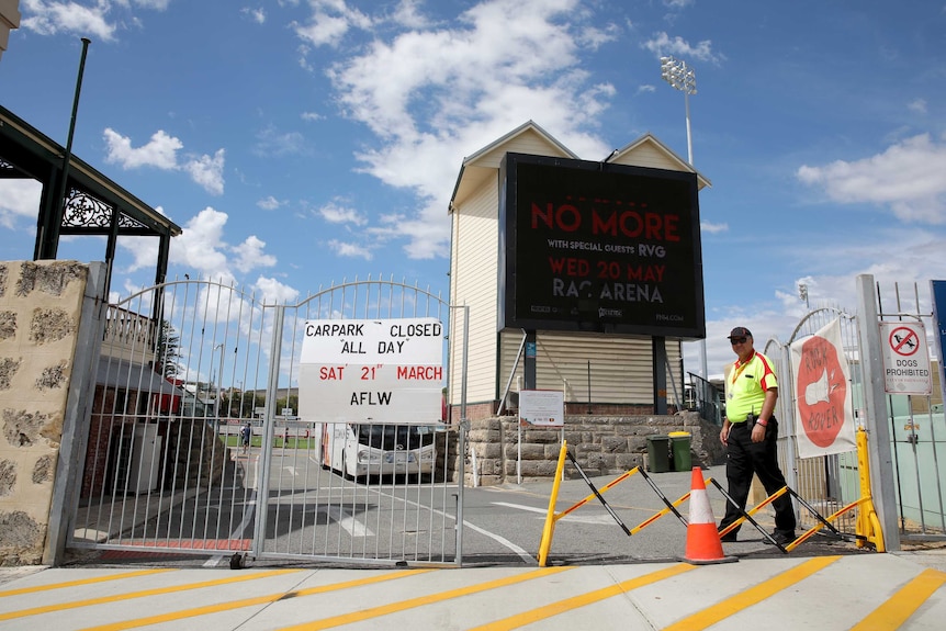 Guards monitor a locked car park at a football ground as AFLW match is played behind closed doors.