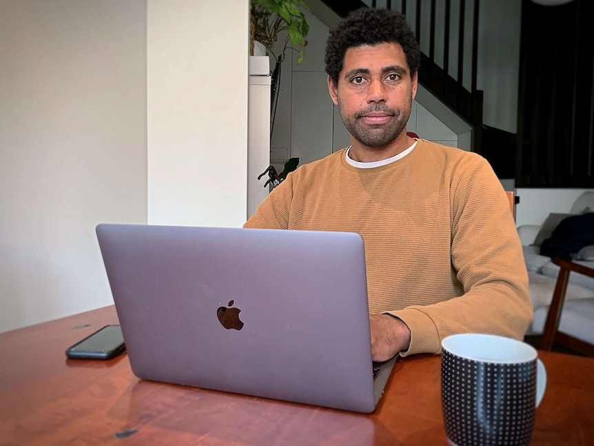 Jesse Kemelfield sits in front of his open laptop computer.