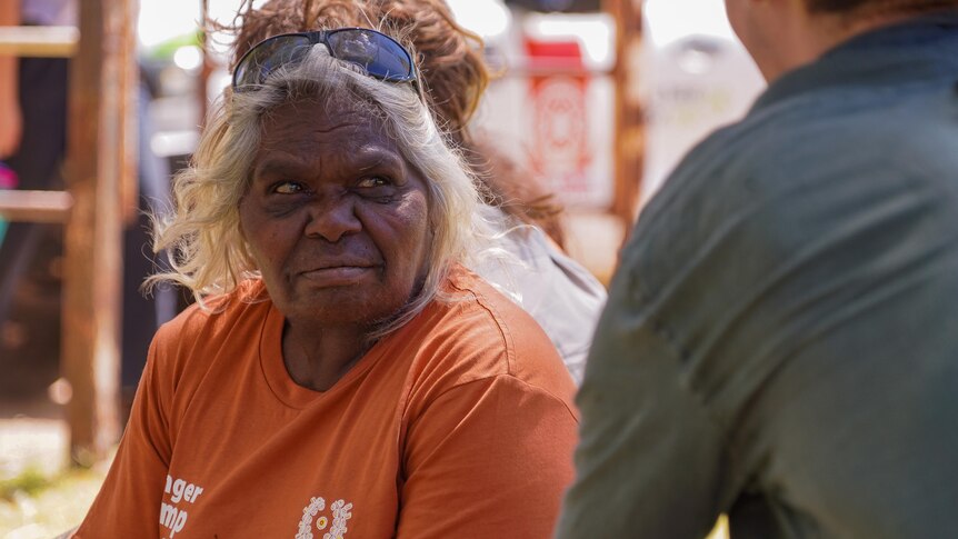 A middle-aged Indigenous woman is interviewed by an ABC reporter.