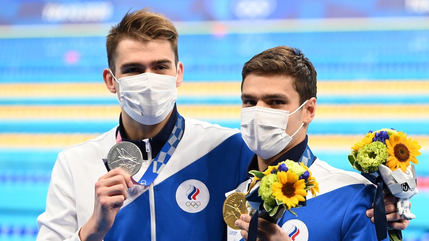 Kliment Kolesnikov hugs Evgeny Rylov both holding medals