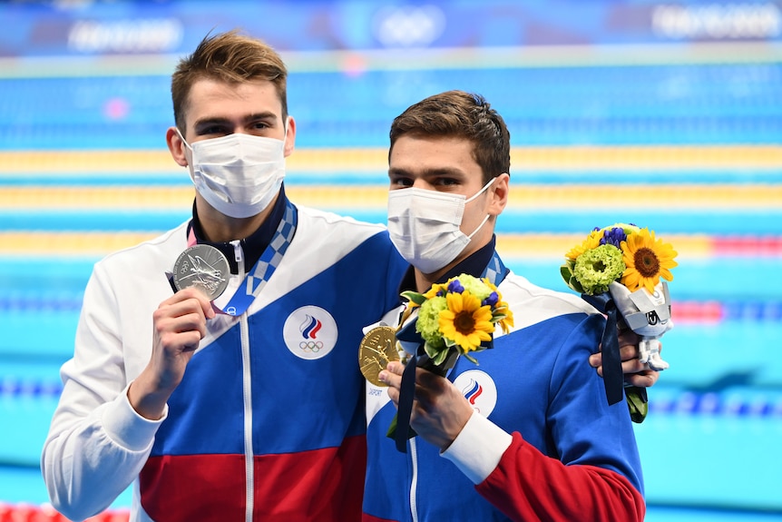 Kliment Kolesnikov hugs Evgeny Rylov both holding medals