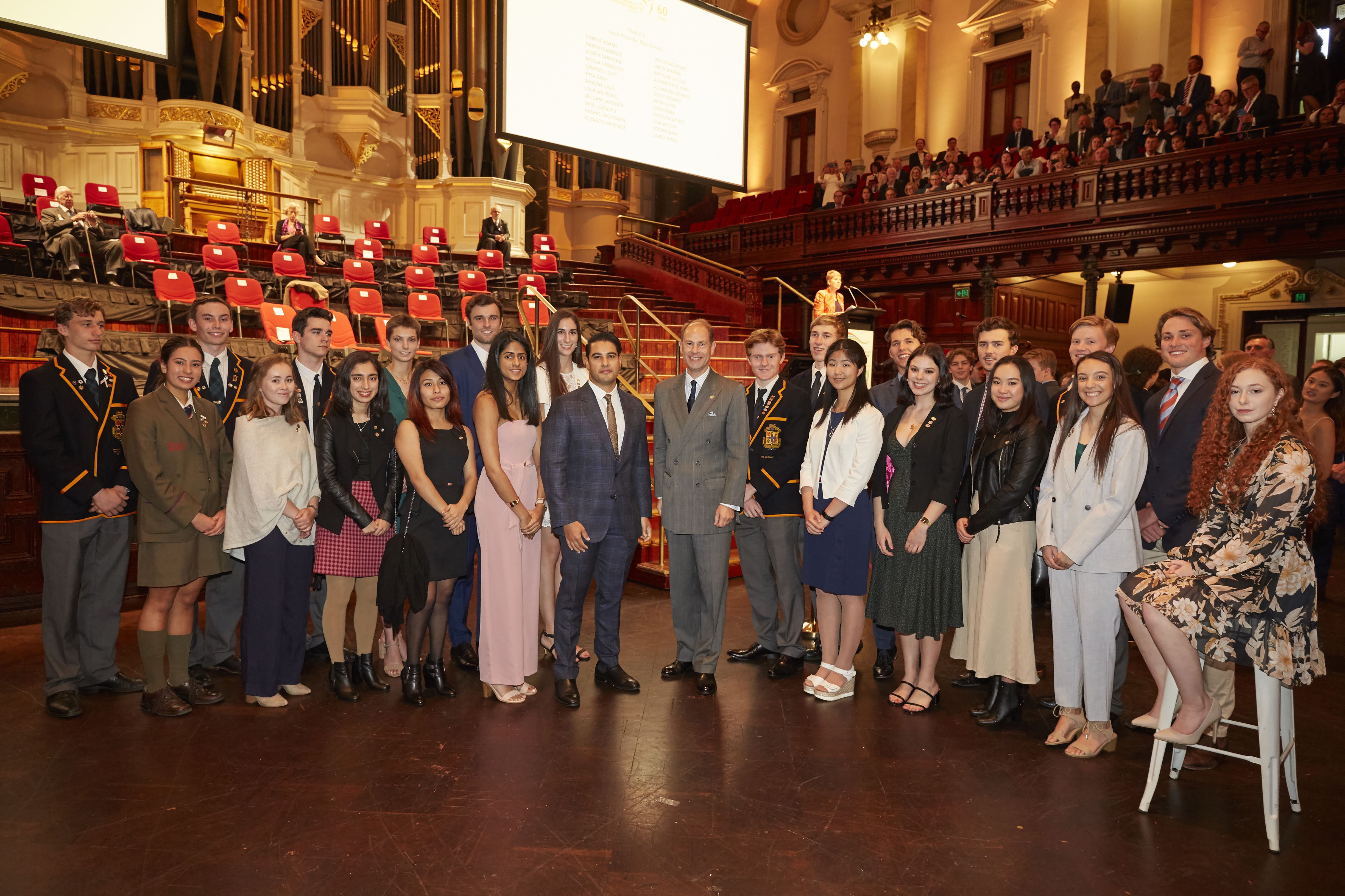 Marc, left, and Prince Edward, right, pose for a photo with about 20 other people.