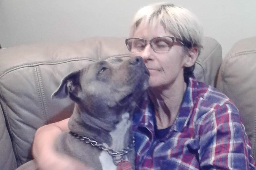 Tamra McBeath-Riley cuddles a Staffordshire bull terrier.