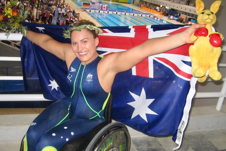 Marayke Jonkers in a wheelchair holding the australian flag.