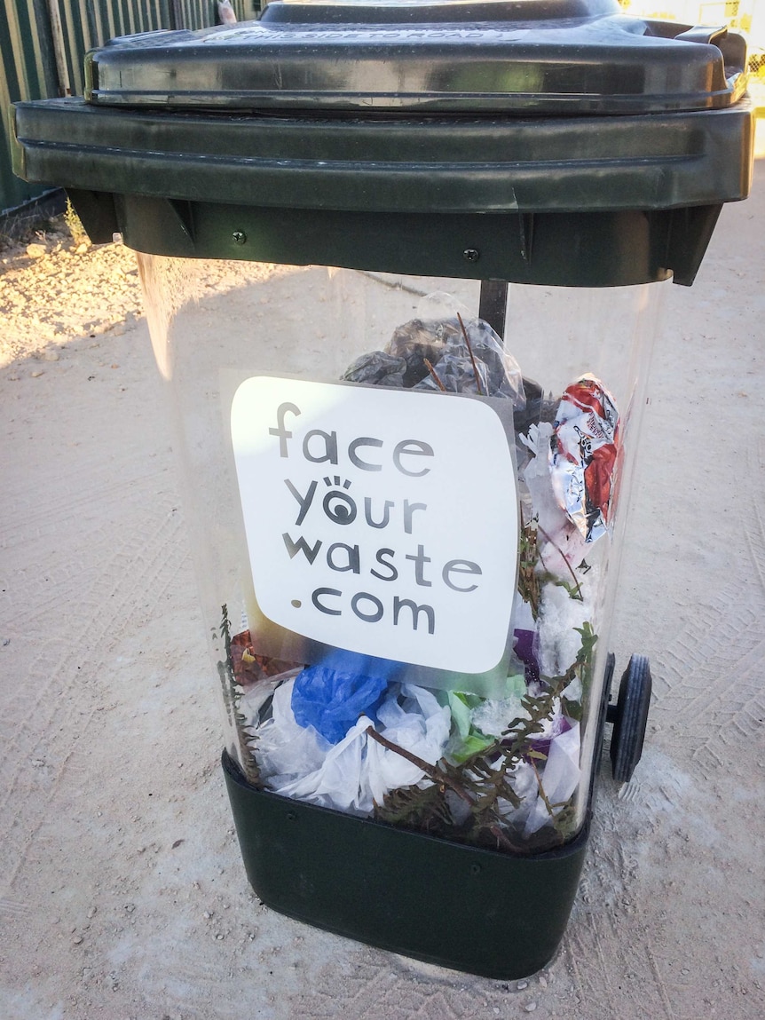 A clear bin with rubbish inside