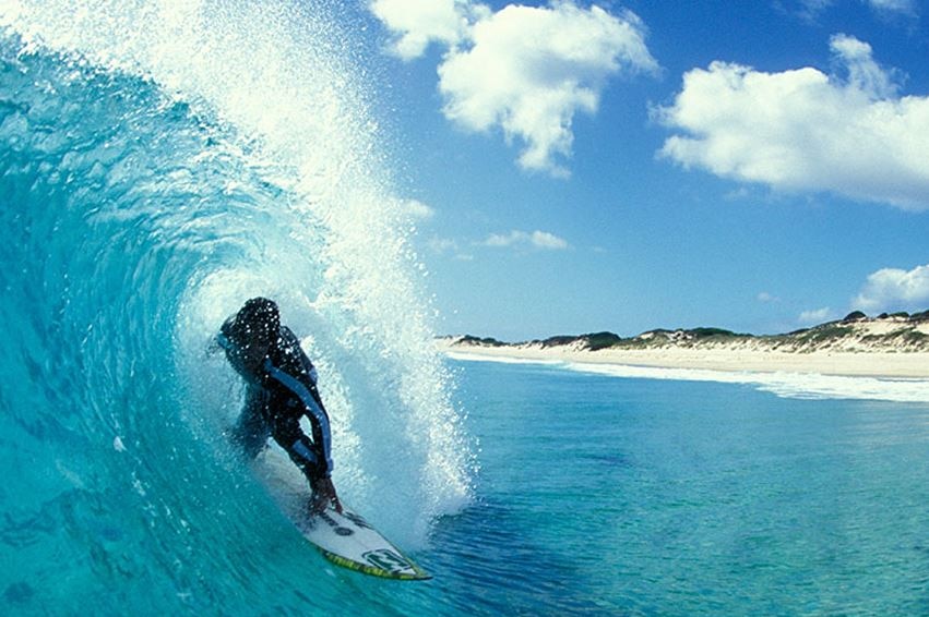 Surfer at catches a wave at Martha Lavinia Beach, King Island, Tasmania.