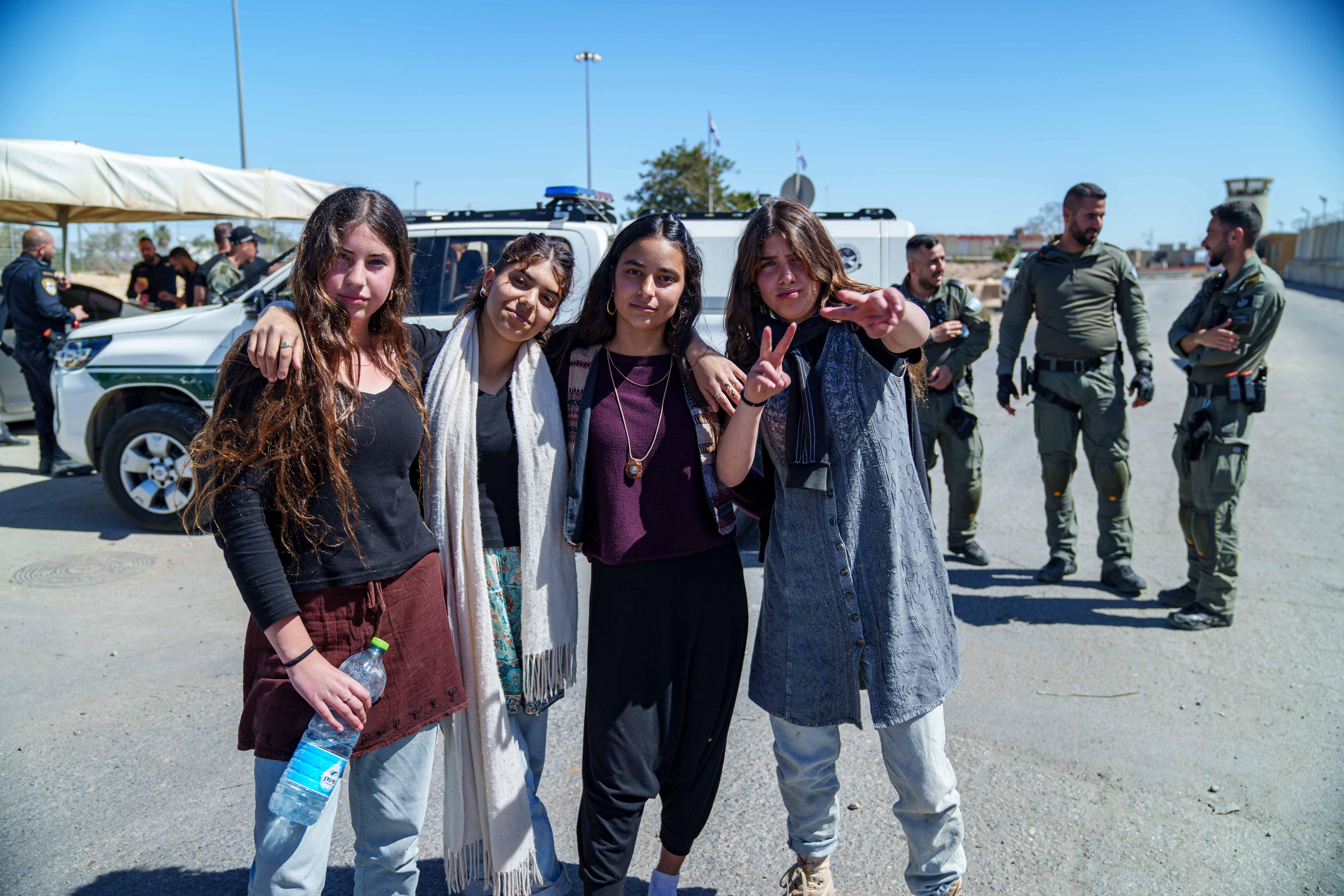 A group of girls throw peace signs for the camera 