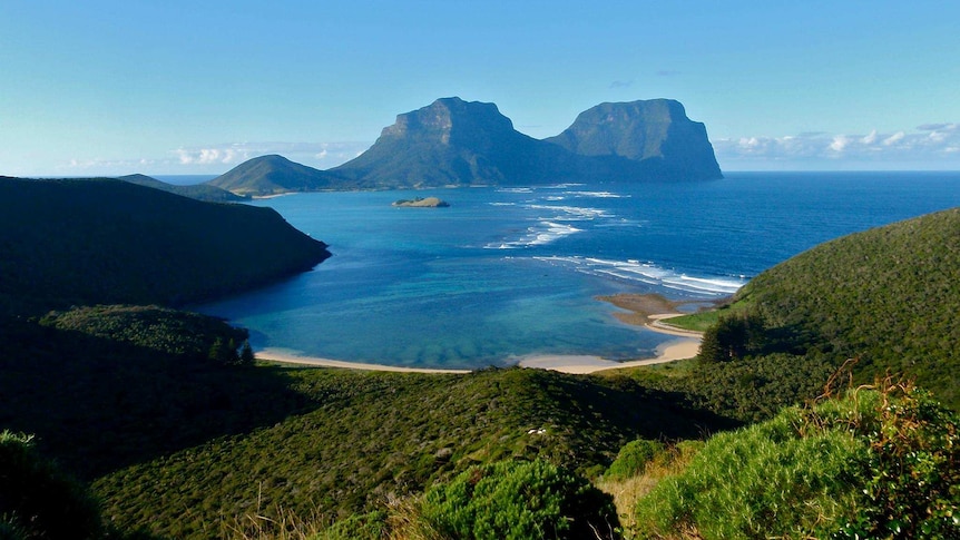 Lord Howe Island with beach in the foreground and rocky outcrops in the background